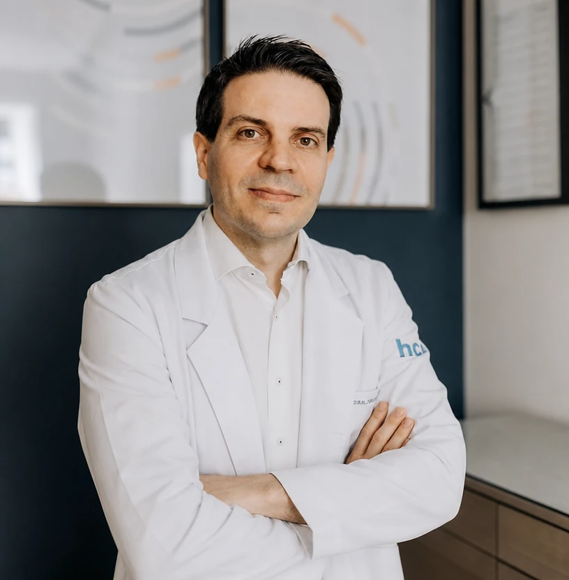 Dr. Ivan Martins, angiologista e cirurgião vascular, de braços cruzados no consultório em São Paulo